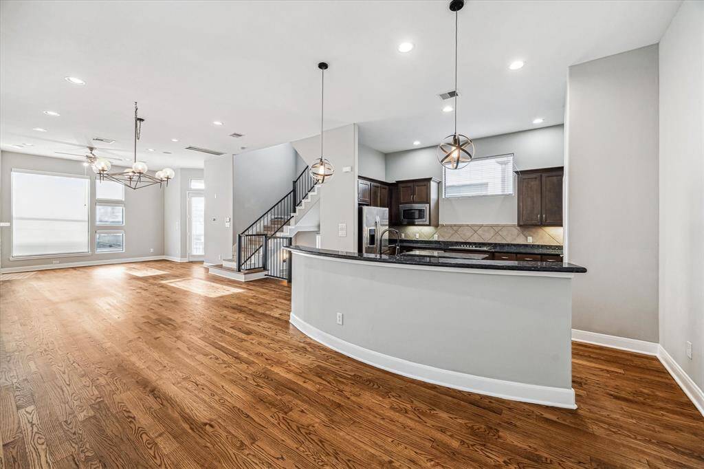 Elegant, contemporary kitchen island anchoring a spacious, open-plan living area.