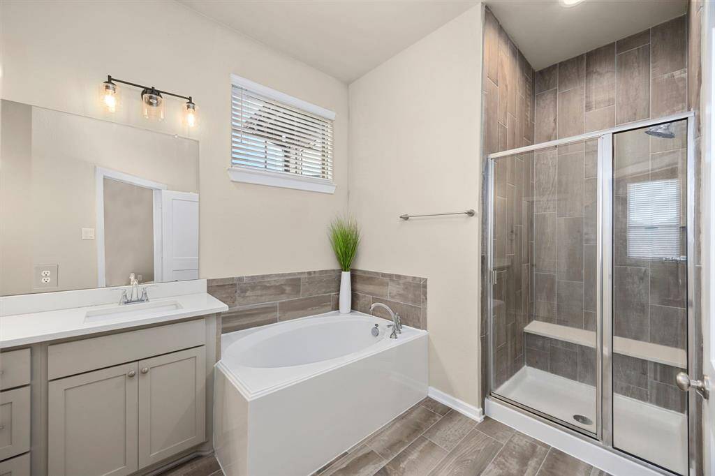 Primary bathroom includes dual sinks, soaking tub, standalone shower, and massive closet.