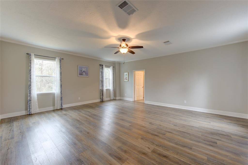 The huge primary bedroom, located on the second/main floor, is a bright and luxurious retreat, bathed in great natural light from expansive windows that enhance its airy and inviting ambiance.