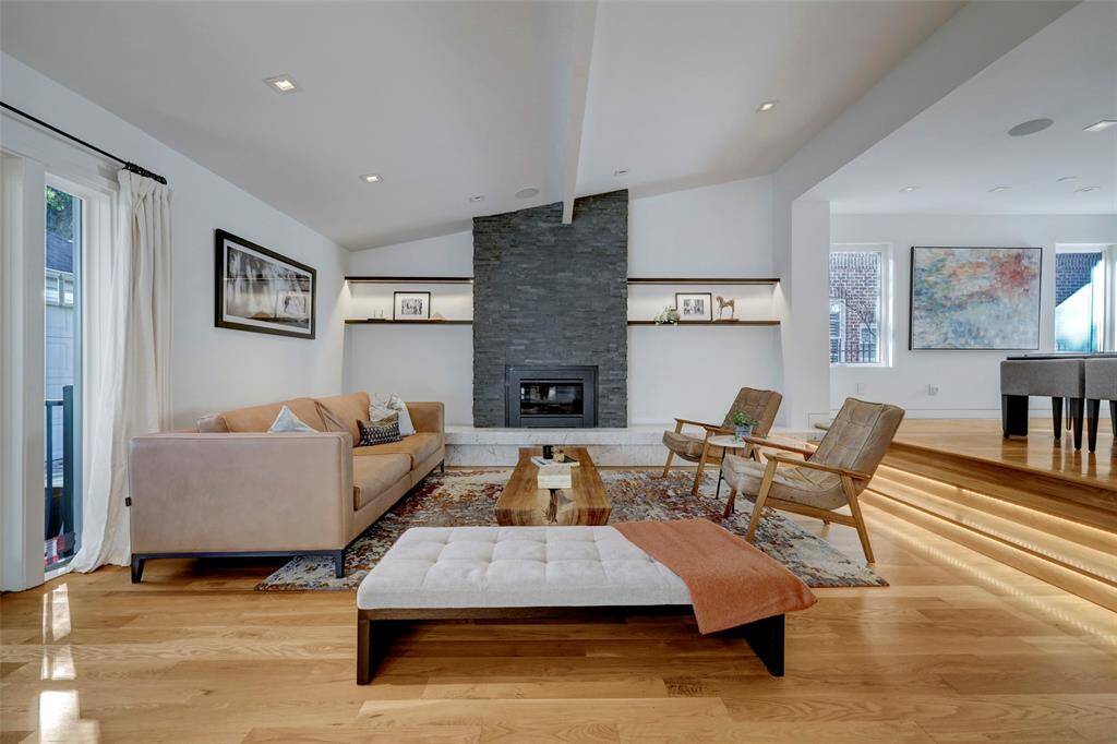The Family Room's stone fireplace is the focal point with custom wood shelving, thoughtful lighting and a Carrara marble ledge.