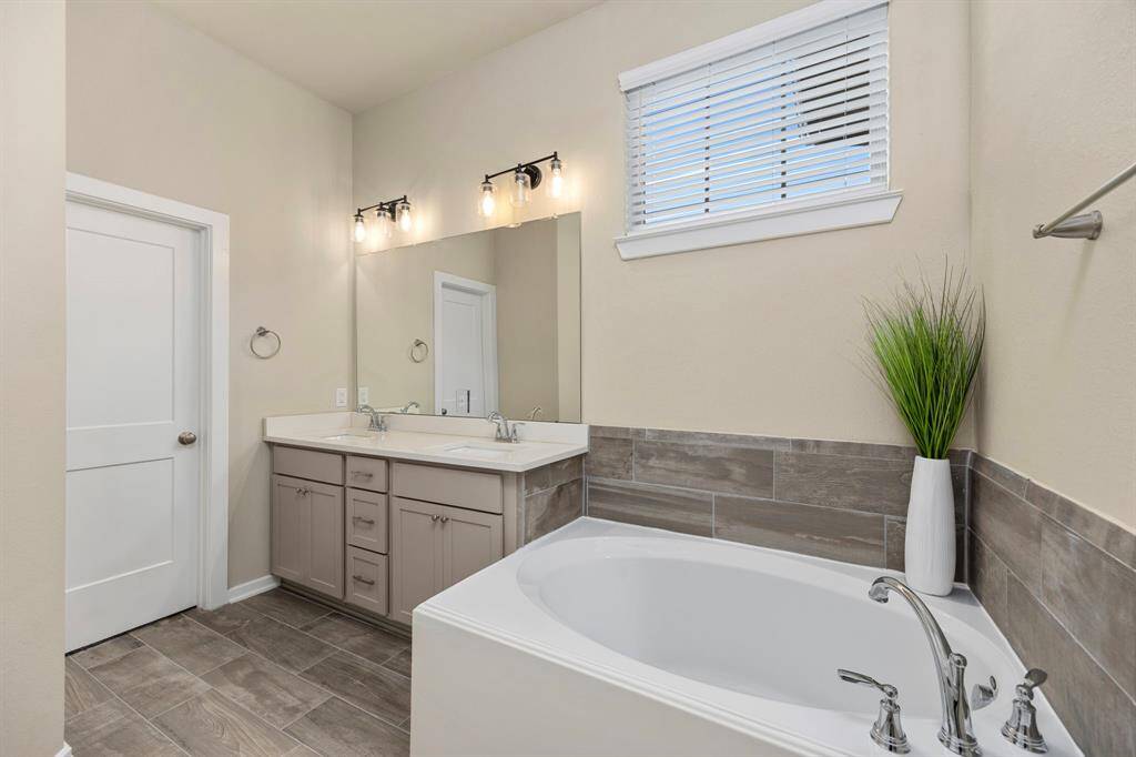 Primary bathroom includes dual sinks, soaking tub, standalone shower, and massive closet.