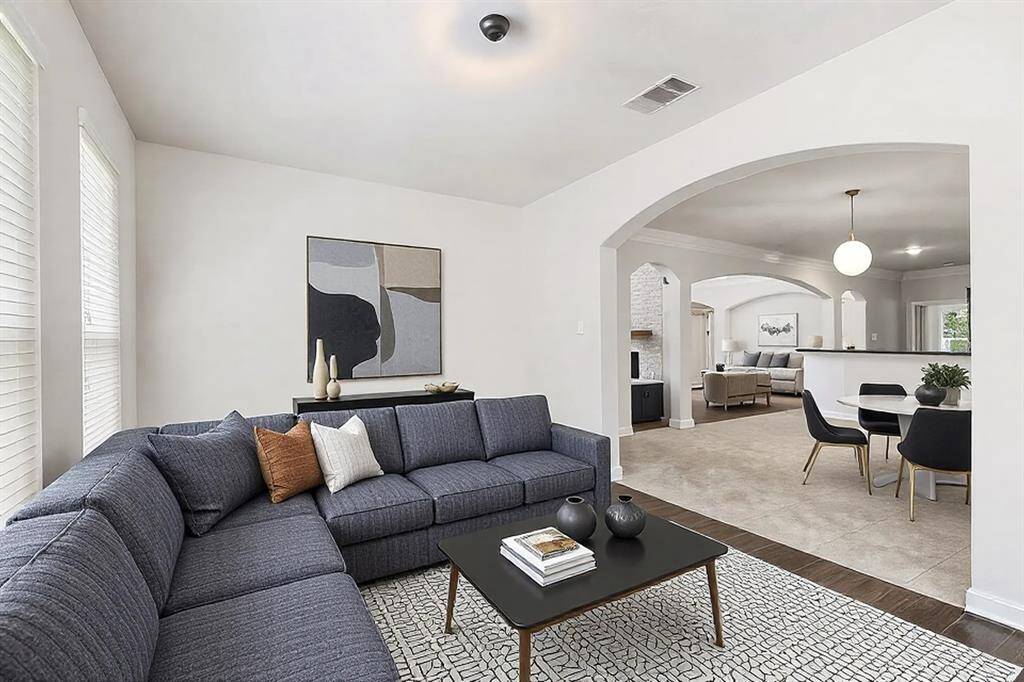 The sunroom is flooded with natural light, boasts wood-looking tile floors and ceiling fan. This home has been virtually staged.