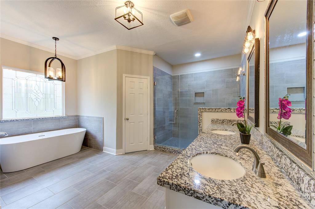 The ensuite primary bath is a true spa-like retreat, designed with both luxury and functionality in mind. Featuring a separate frameless glass shower and a deep soaking tub, this space offers the perfect blend of relaxation and elegance.