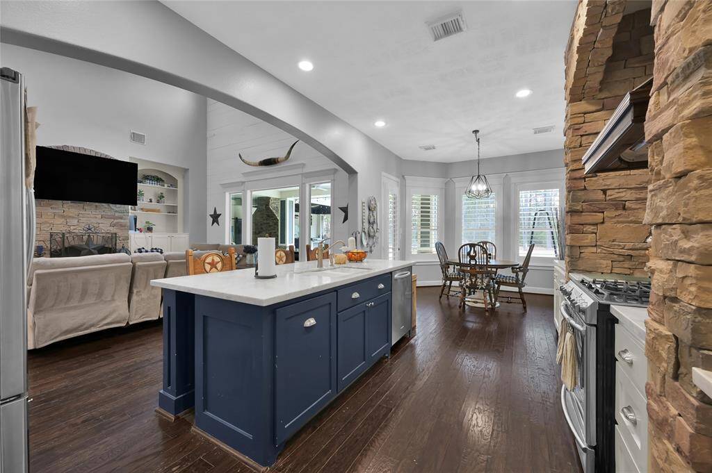 Kitchen includes a gas cooktop, stainless steel appliances, and a dine at island