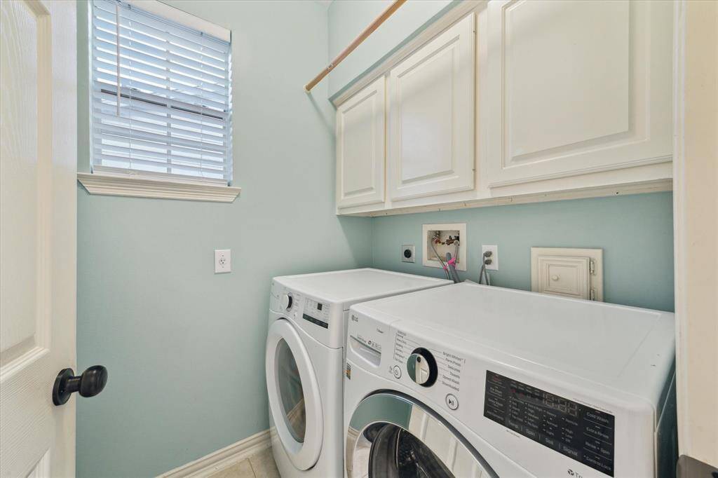 Downstairs laundry room with cabinet storage.