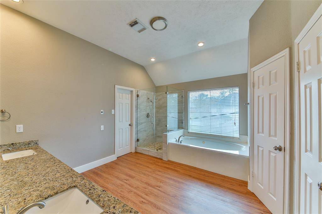 En suite has separate shower, jetted tub, toilet closet, double sinks, and two walk-in closets