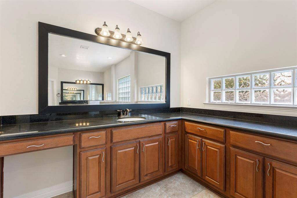 The primary bathroom features two oversized vanities with separate sinks and an excess of storage. Granite counters and so much space to spread out.