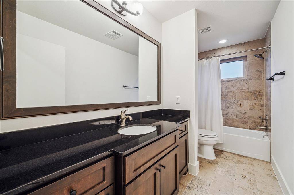 Guest bath (3rd floor): 3rd floor ensuite boasts "Midnight" granite counter tops, custom tile back splash, custom vanity mirror, Nickel hardware, Kohler under-mount sink, Cifial brushed Nickel shower head, and full tub-shower combo.