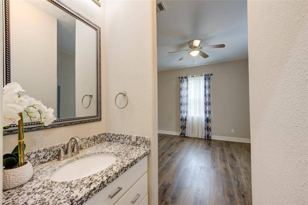 This view of the Hollywood bath shows bedroom number 3 has it's own vanity and storage, joined by the separate shower and additional storage and counterspace.