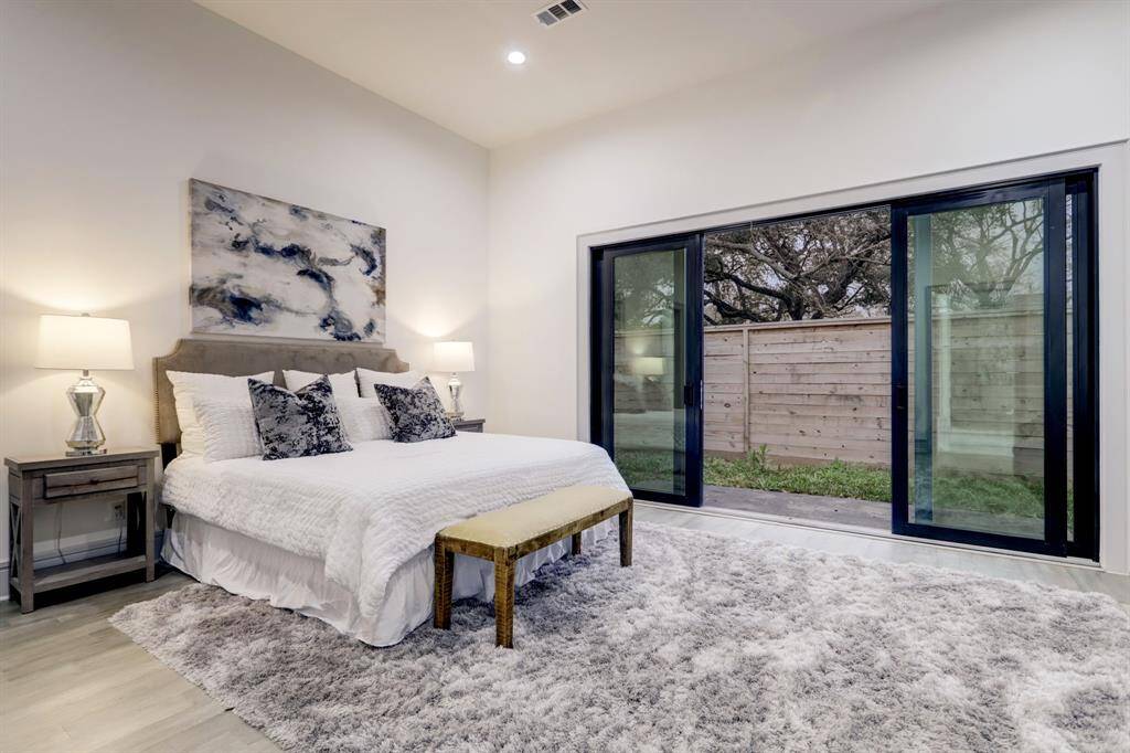 12' ceilings and sleek glass doors enhance the comfort of the primary bedroom.