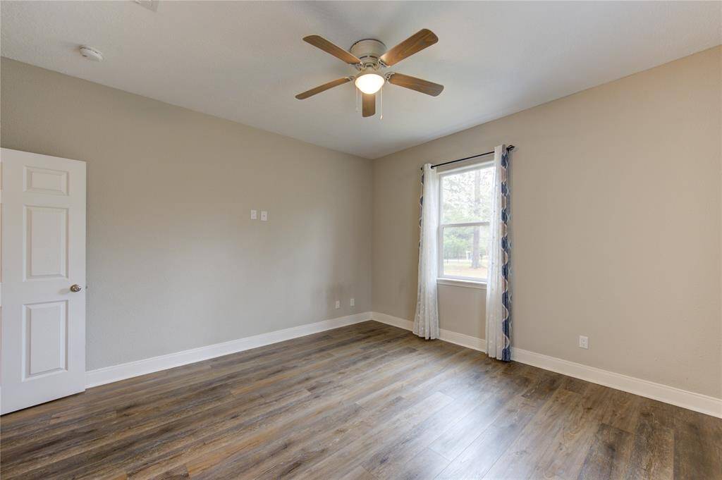 The view from bedroom number 3 showcases the front yard, and gate.