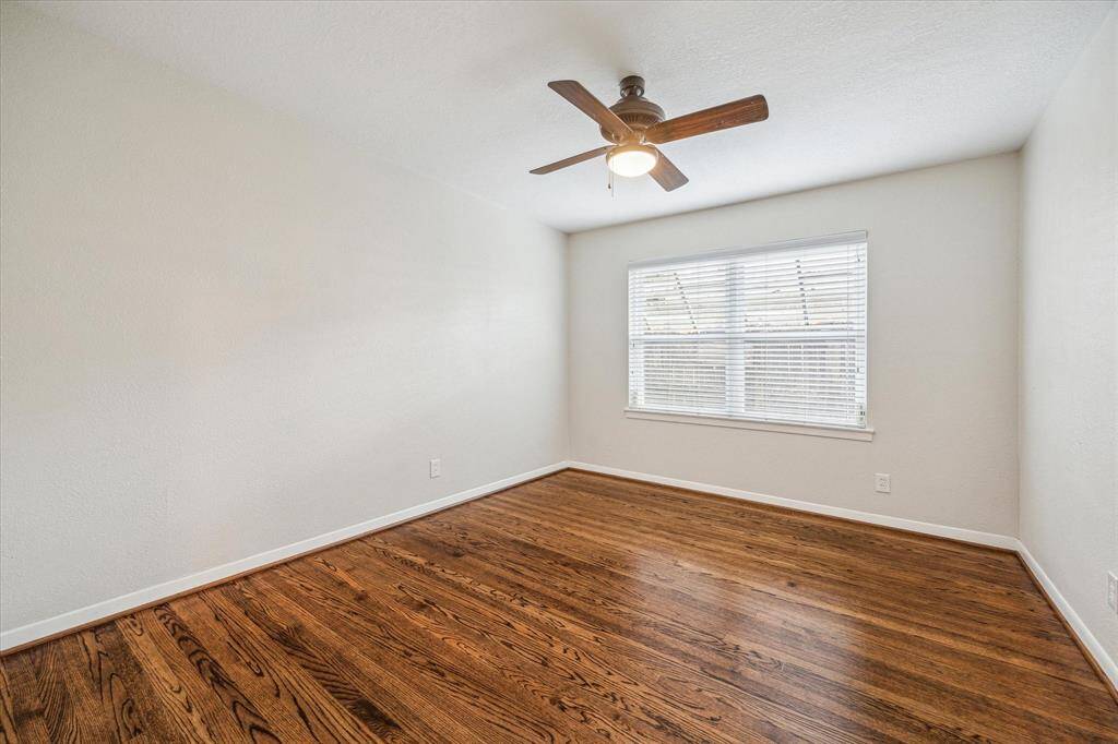 Guests will feel right at home in this spacious bedroom with hardwood flooring, neutral paint, a lit fan, large closet and easy access to an updated full bathroom.