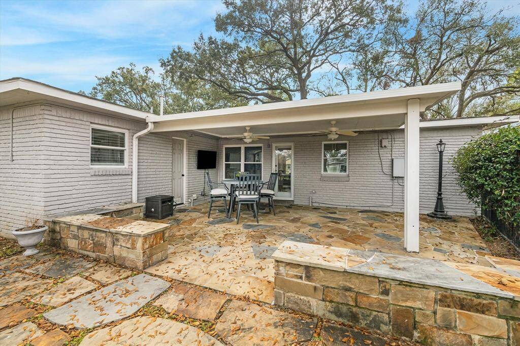 An expansive flagstone patio offers the perfect space for entertaining, featuring both covered and open areas. Whether hosting summer BBQs or backyard birthday parties, this inviting outdoor retreat is ready for every occasion.