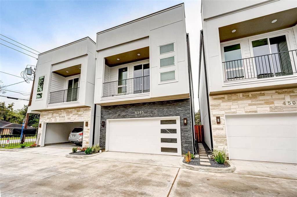 The home has a stacked stone and stucco exterior and 2 car garage. Front door is down path to right in photo.