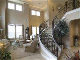 Grand entry with sweeping stairway surrounding the formal living room and dining room