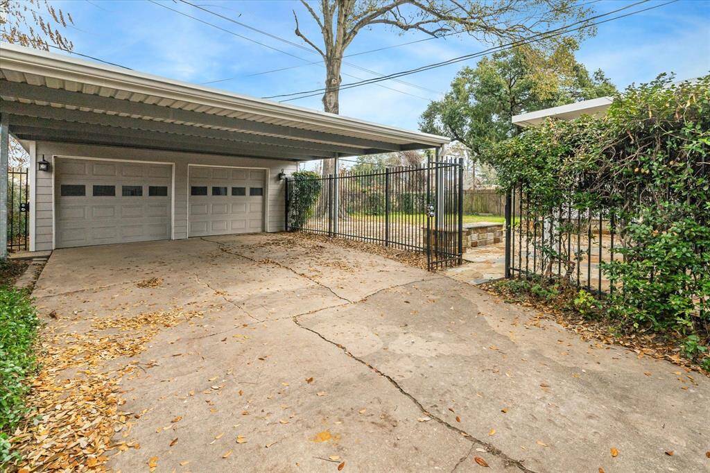 A two car detached garage and covered carport parking for two vehicles is tucked behind a private driveway gate.