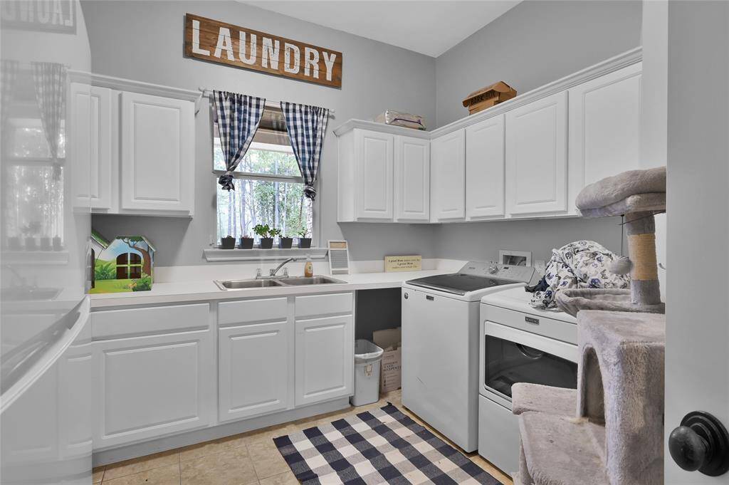 Large open laundry room with sink, refrigerator, and plenty of storage