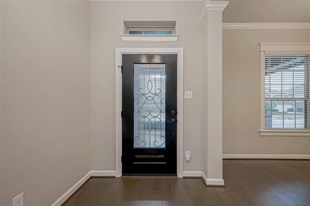 As you enter the home - you are greeted by seamless wood flooring, and a glow of natural light.