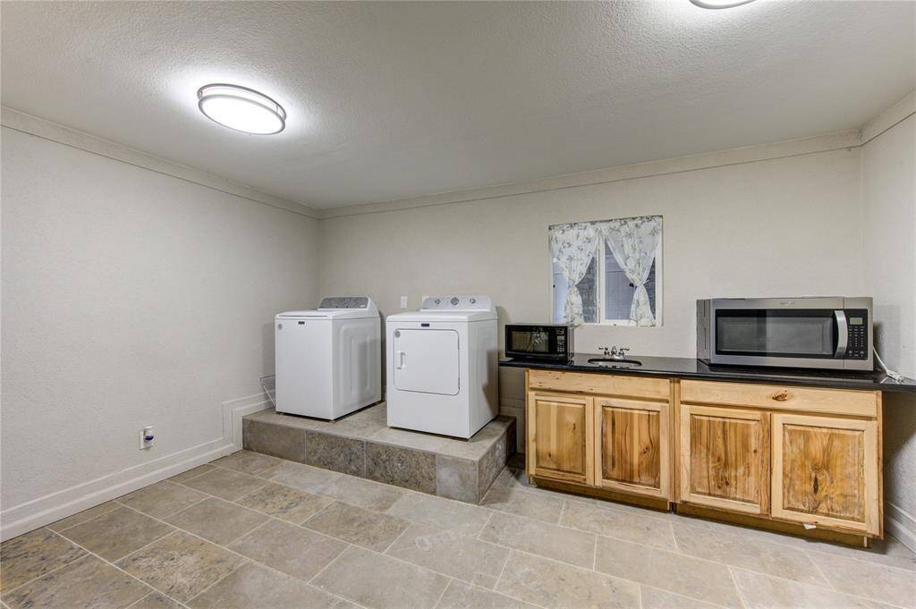 This room is incredibly versatile, offering multiple possibilities to suit your needs. Whether utilized as a dedicated laundry room, a second kitchen, or a combination of both, this space provides exceptional convenience and functionality.