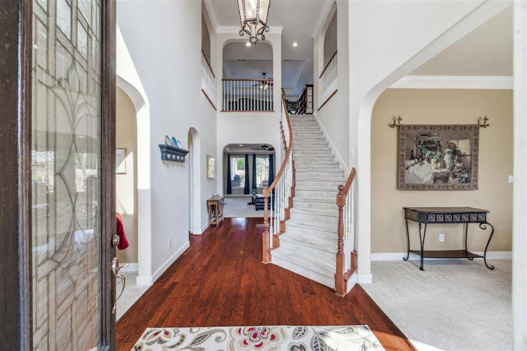 WELCOMING FOYER WITH CURVING STAIRCASE - wood flooring, decorative pendant light - foyer is flanked by formal living room and dining room