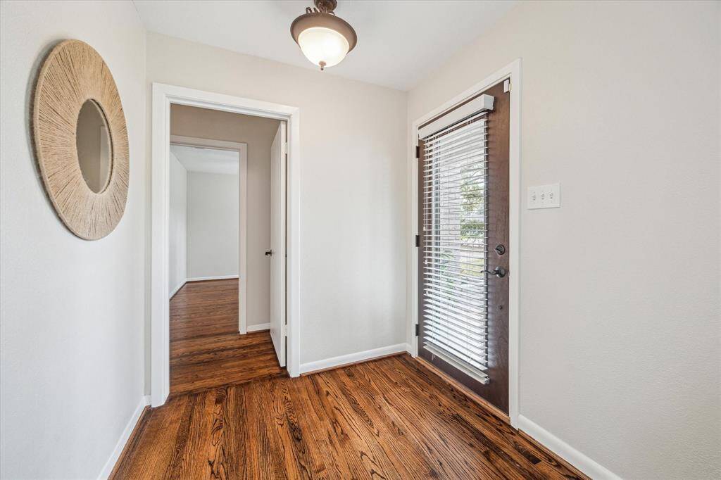 This foyer is a wonderful space to welcome guests into your home with stylish lighting, hardwood flooring, and neutral paint.