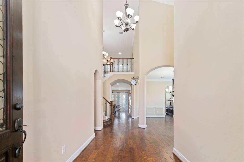 Welcoming foyer with sky-high 2-story ceilings and neutral-painted walls