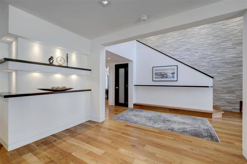 The home feels elegantly designed with attention to detail by using luxury materials like custom wood shelving and thoughtful lighting.