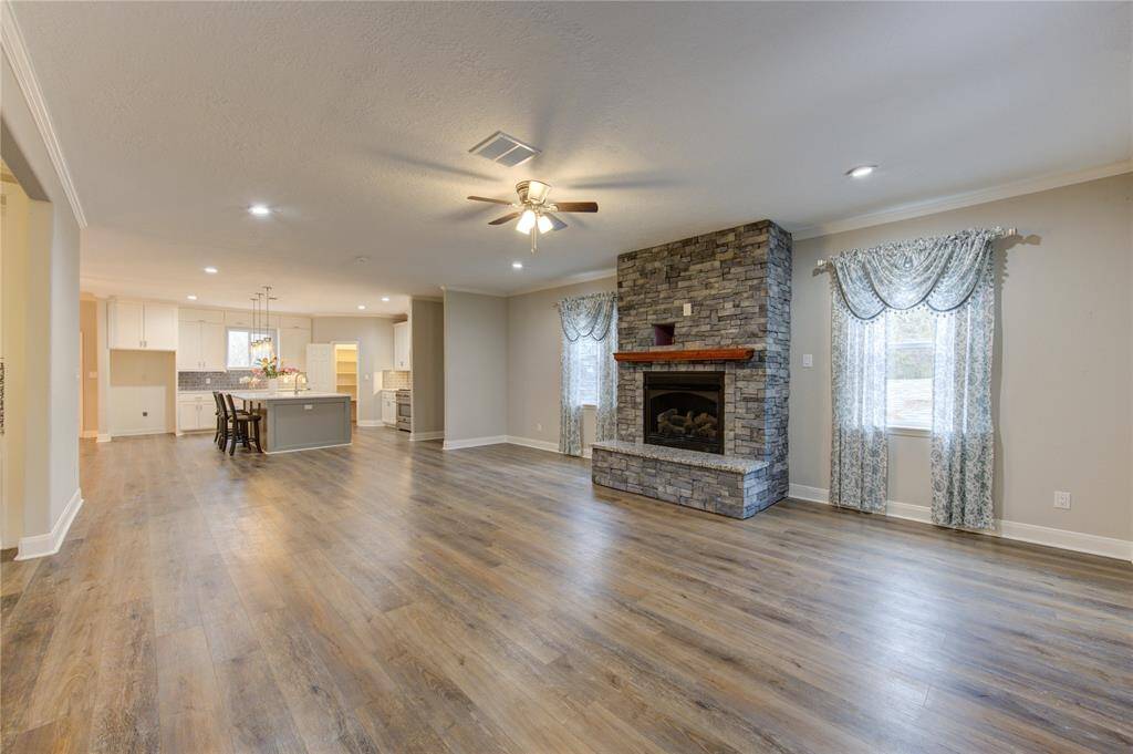 The 2nd/main floor living room, bathed in abundant natural light, seamlessly opens to the gourmet kitchen, creating a space that is both inviting and effortlessly functional.