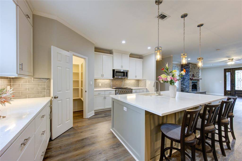 From this vantage point, the kitchen is a true showstopper, offering an excellent view of its stunning design and impeccable functionality. Just beyond, the walk-in pantry offers incredible storage.