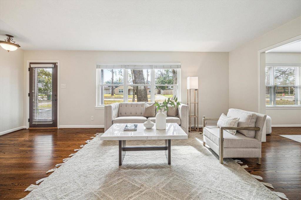 The living/family room is a wonderful space to visit with guests. This spacious living room features hardwood floors, neutral paint, and ample space for large cushy furnishings so everyone can gather here and relax comfortably.
