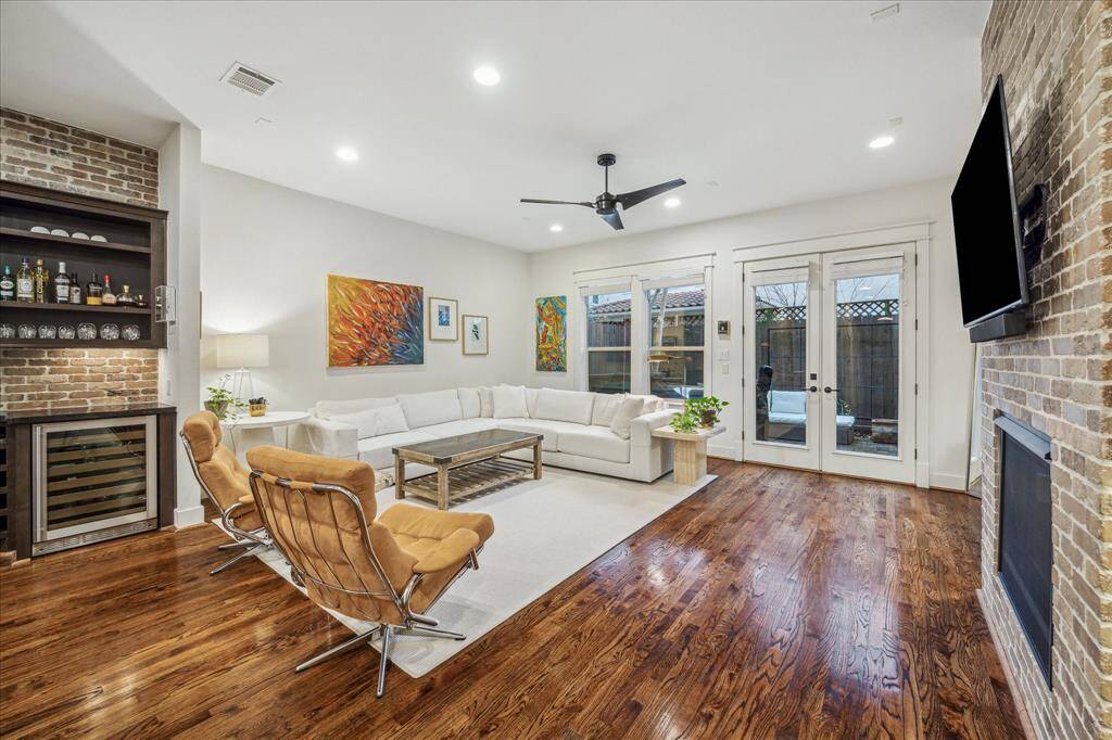 Living Room: Magnificent garden- home built as an extraordinarily unique and sophisticated property boasts living areas with recessed and art lighting, gas-log fire place, hardwood floors, and French doors.