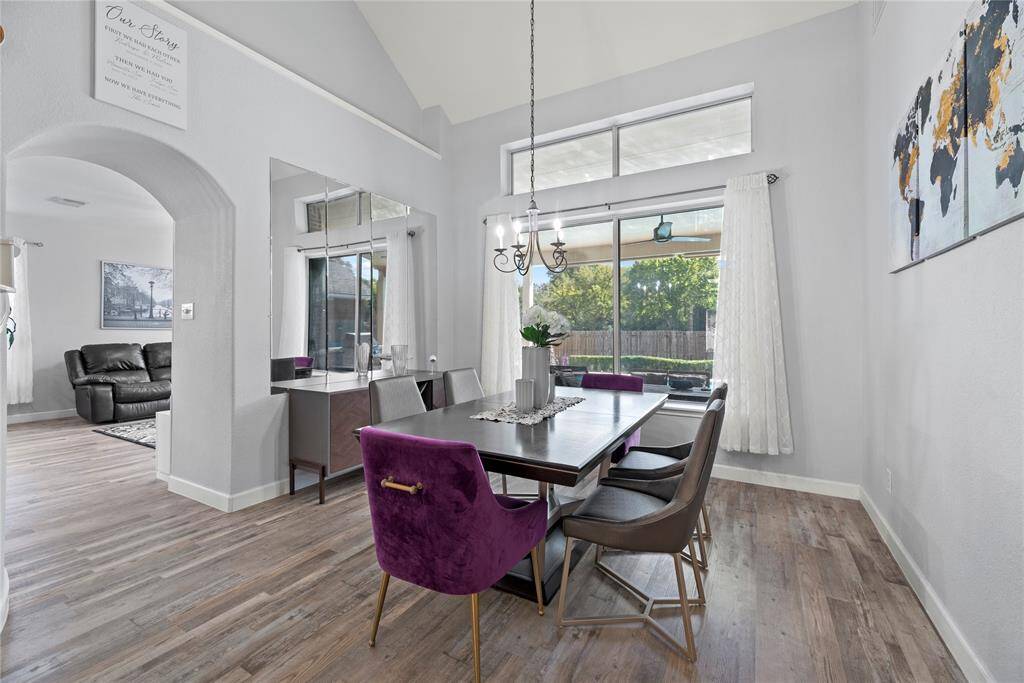 Elegant dining area with decorative light and vinyl plank flooring
