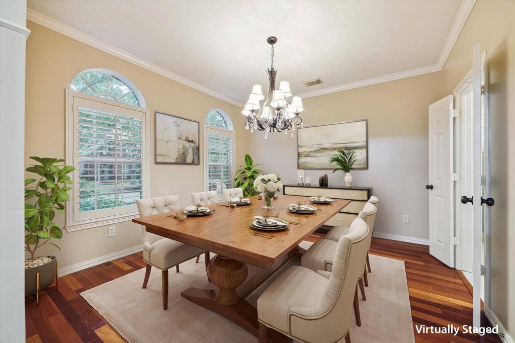 Formal dining adjacent to the kitchen features wood floors, and plantation shutters.