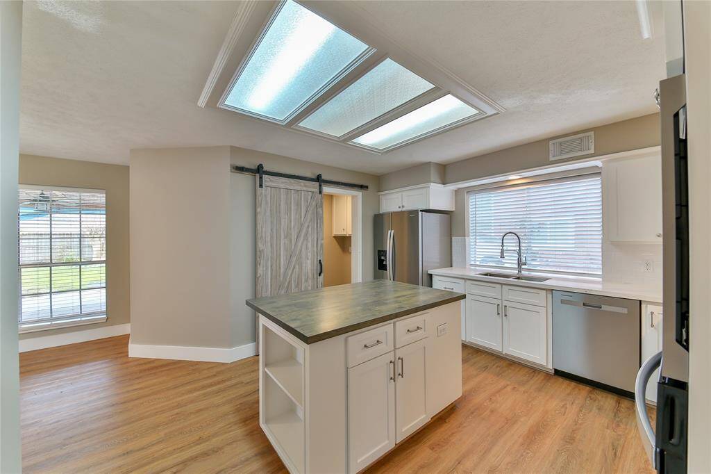 Kitchen; barn door leads to laundry room, half bath, and back yard