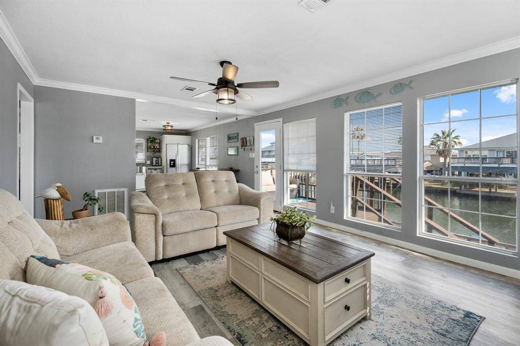 The living area, bathed in natural light, transitions effortlessly into a modern kitchen with breathtaking waterfront views.