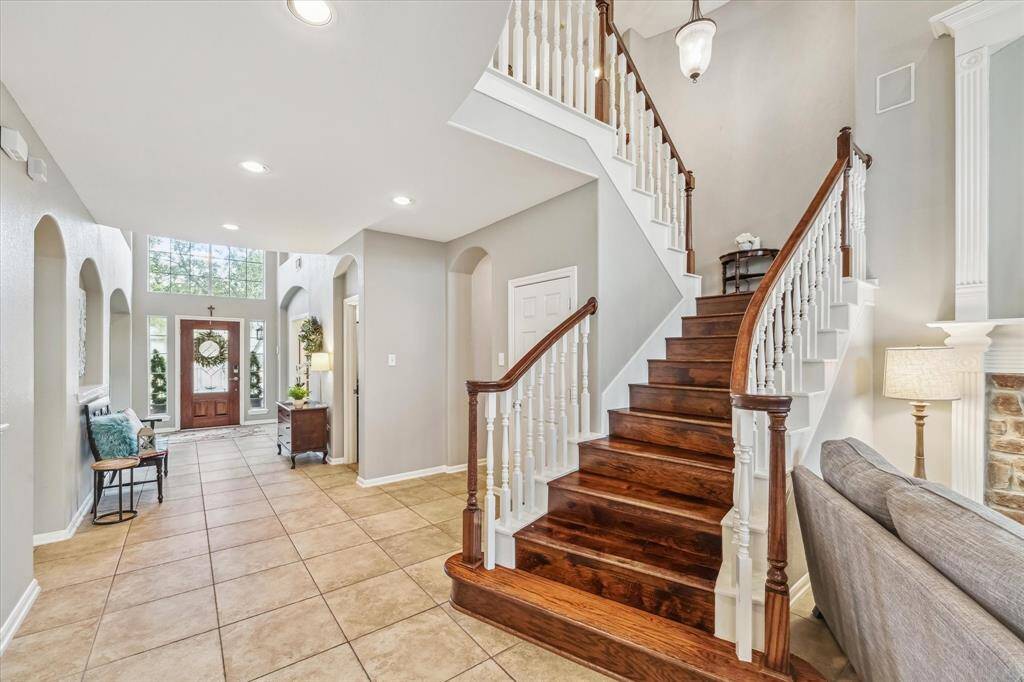 A beautiful first impression of the foyer into the family room with soft grey palette and art niches. Lots of natural lighting throughout the home.
