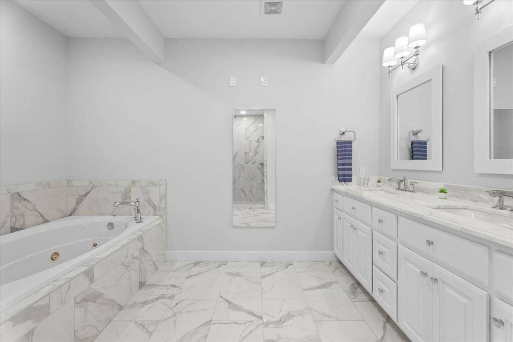 The Owners Suite features a vanity with double sinks, a separate jetted tub, dressing mirror, walk-in shower and private water closet.