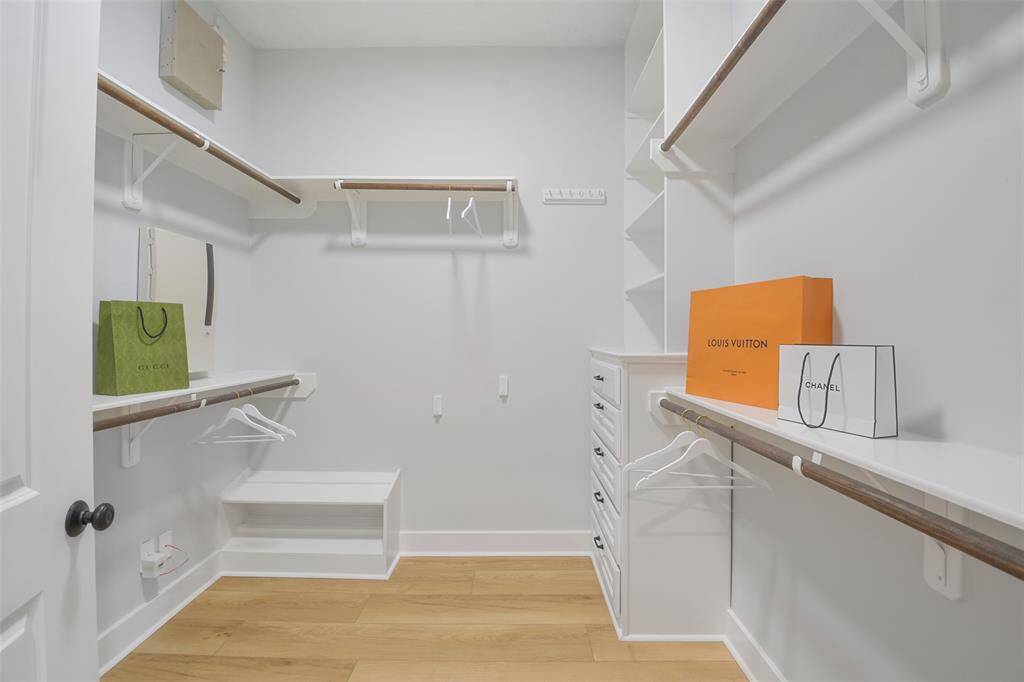 Oversized walk-in closet within the Owners Suite with hanging space, shoe rack and built-in cabinetry.