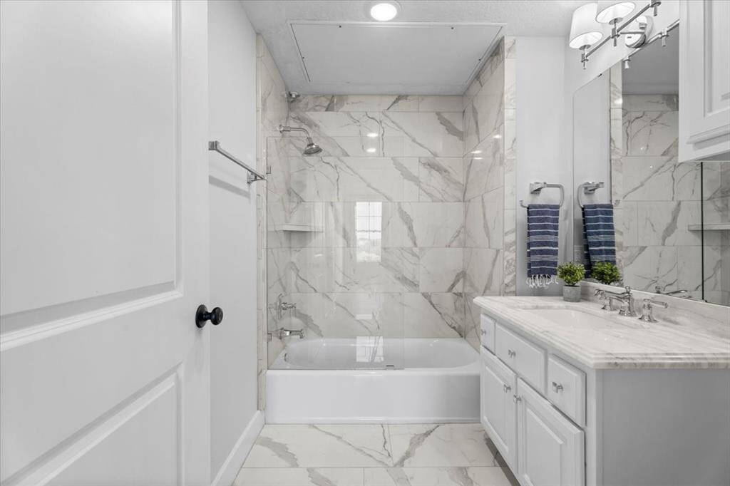 One of three bathrooms, this ensuite is located in the Guest Suite with a tub shower combo and vanity.