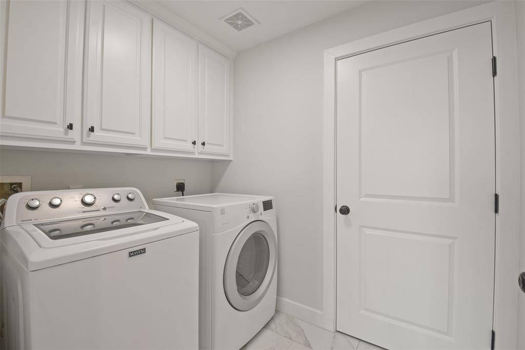 Laundry located within the condo with overhead custom cabinetry and electrical closet with additional storage. Washer and Dryer convey with the home.