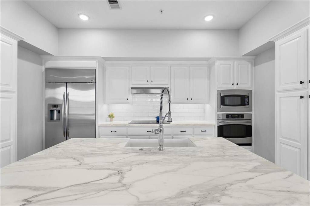 Don't miss the details...custom cabinets with under cabinet lighting, new induction cooktop, marble countertops and a polished chrome Kohler Tournant Faucet with three-function sprayhead.