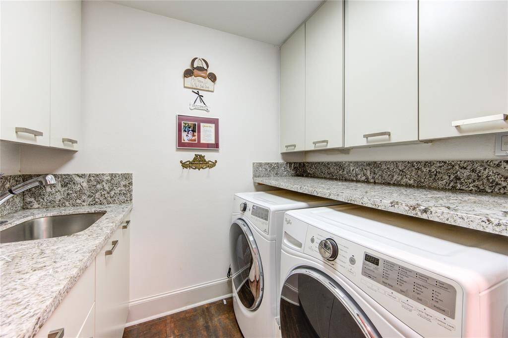 1st floor laundry room with ample cabinetry for storage and built-in sink. t features a counter above appliances providing a functional and stylish space for laundry tasks.