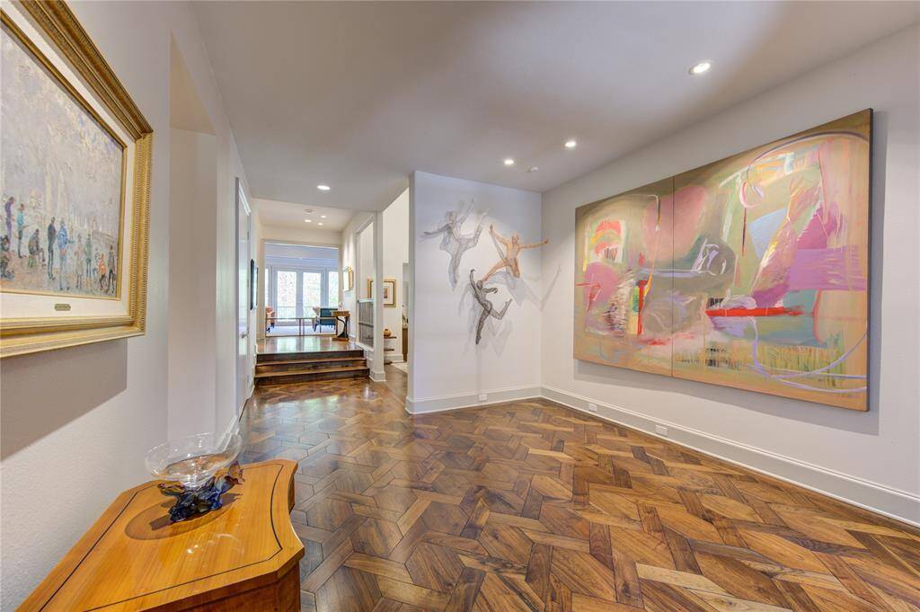 Elegant entry with patterned wood flooring and fantastic walls for art display. Recessed lighting, leading to a family and livings rooms.