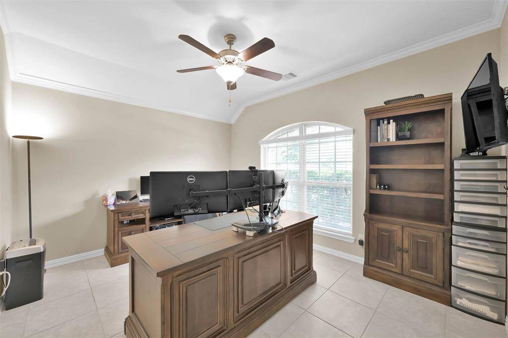 The home office with high ceiling, crown moulding, and tile flooring! And you get the benefit of the natural light coming through the large window.