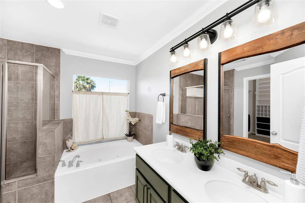 The primary bath with dual sinks and mirrors, soaking tub, separate shower, water closet with bidet, and walk-in closet.