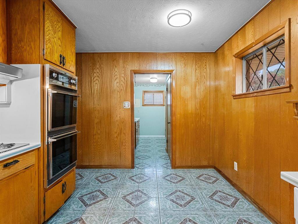 Just below the diamond lattice deigned window is a space in the kitchen to add a breakfast table, shelving, or a chef's working island.  In-home laundry room access seen in this pic.
