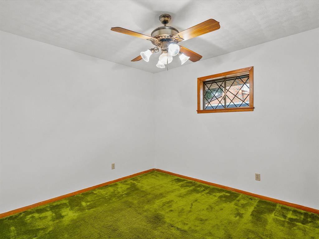 Wood baseboards & matching window frame provide a finished look to this secondary bedroom.