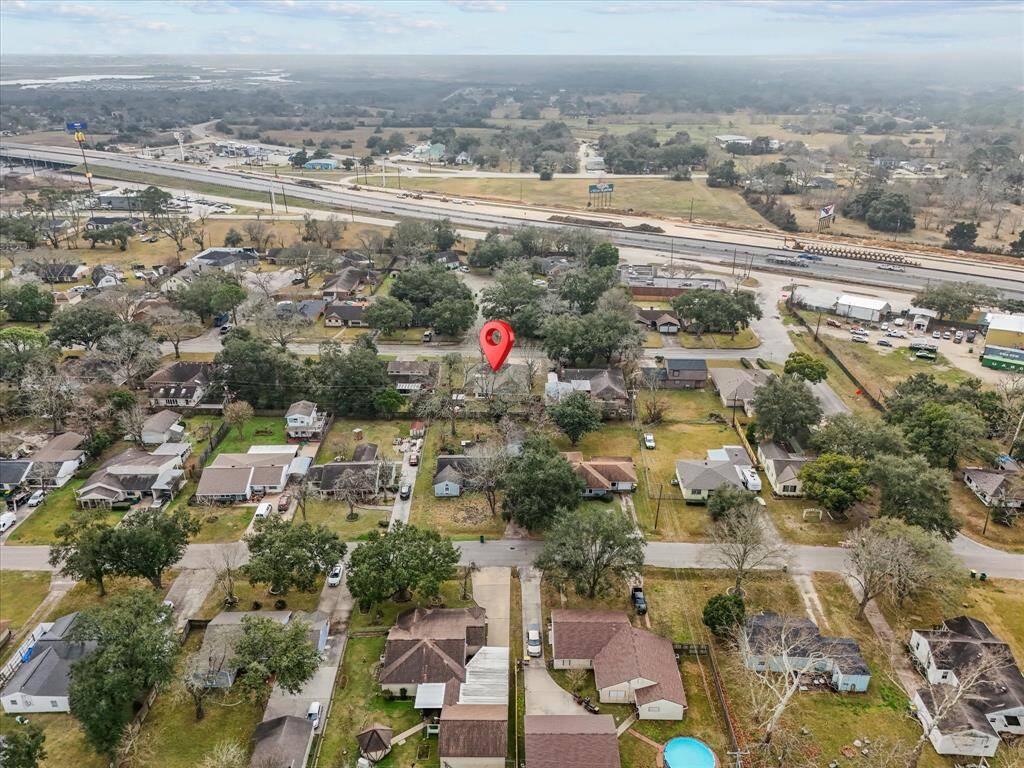 Suburban neighborhood with a mix of single-family homes, mature trees. The area is near a major highway providing convenient access - location, location, location. The landscape is open with a few trees, offering a balance of privacy and community.