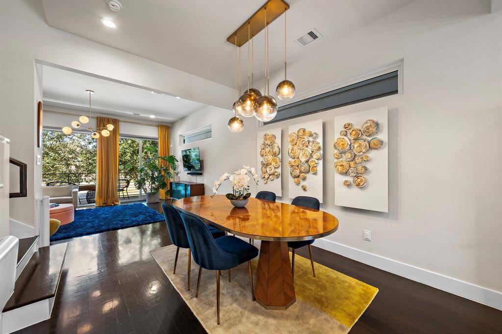 Set the stage for elegant dining in this open layout with designer globe lighting and rich hardwood floors. Large windows offer abundant natural light while connecting to the spacious living area, creating a seamless flow for entertaining and everyday enjoyment.