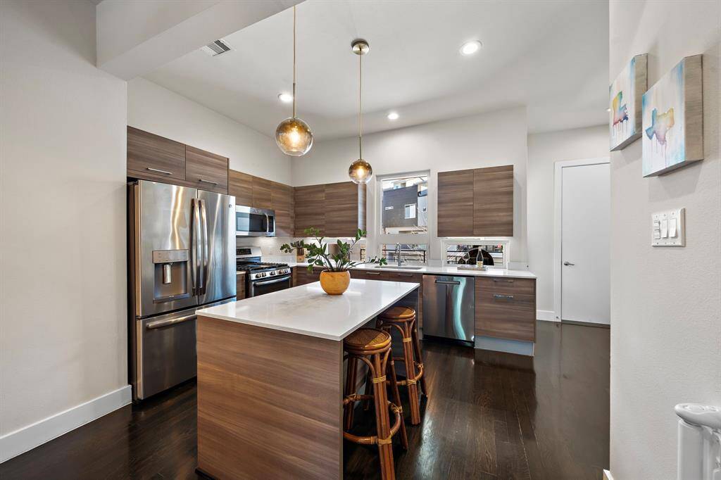 Sleek and contemporary, this kitchen boasts stainless steel appliances, a gas range, and modern backsplash. The spacious island with counter seating seamlessly connects to the dining area, while recessed lighting illuminates the space. Ideally suited for both casual meals and entertaining, this kitchen embodies functionality and style.